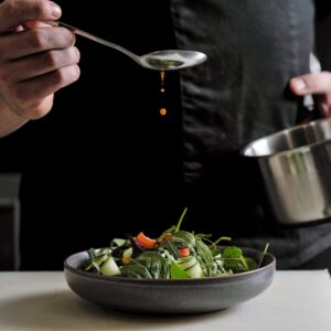 A chef pouring sauce
