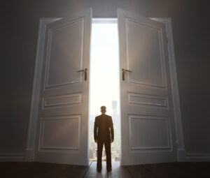 Door to Future Alt: Man standing in front of an open door to his future