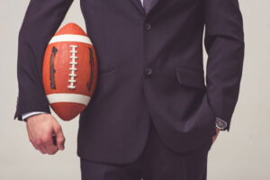 Picture of salesperson in a suit holding a football