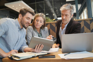 Smiling sales team working through presentation with sales leadership expert on sales forecasting
