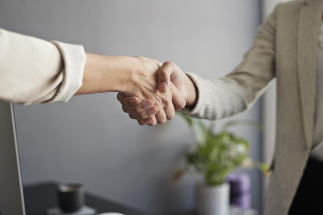 Sales rep shaking hands, accepting a sales manager position