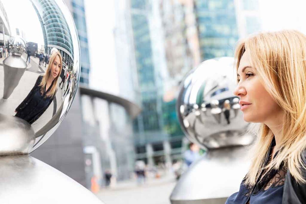 Business Woman Looking at Reflection in Mirror